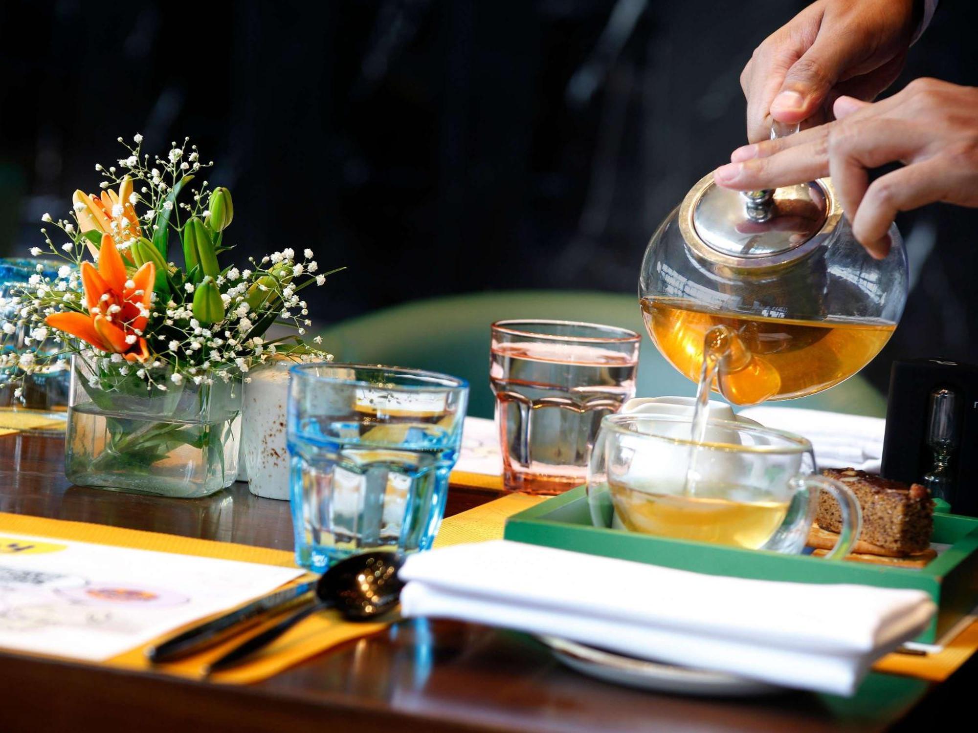 Novotel Kolkata Hotel And Residences Eksteriør bilde A server pours tea at a restaurant